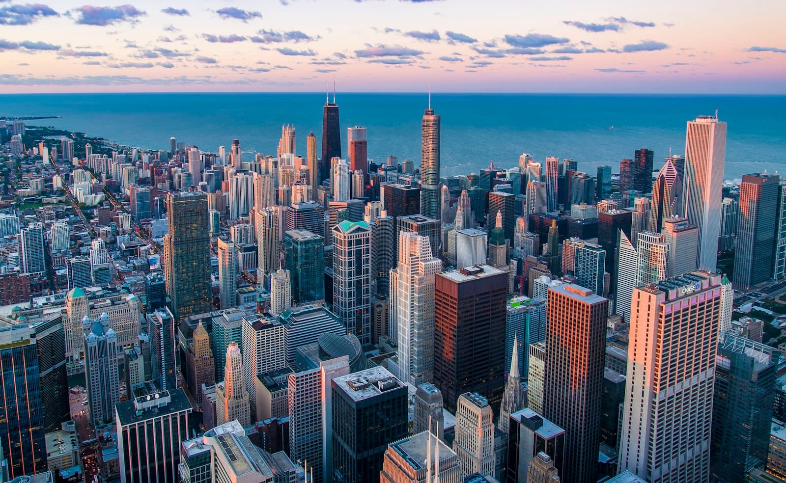 An aerial view of a dense city skyline at dusk.
